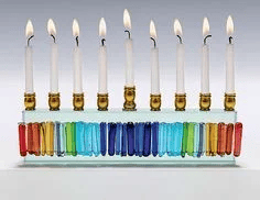 חנוכיה צבעונית שהנרות מונכים בתוך "אומים"